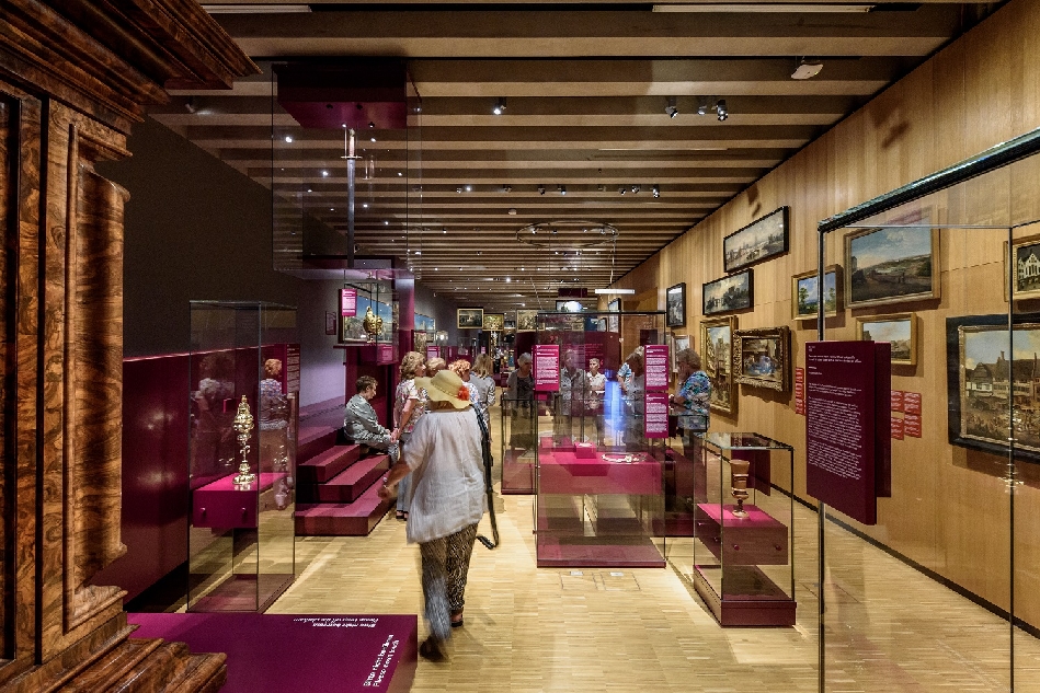 Ausstellung im Historischen Museum mit Vitrinen und Gemälden sowie Besucher*innen