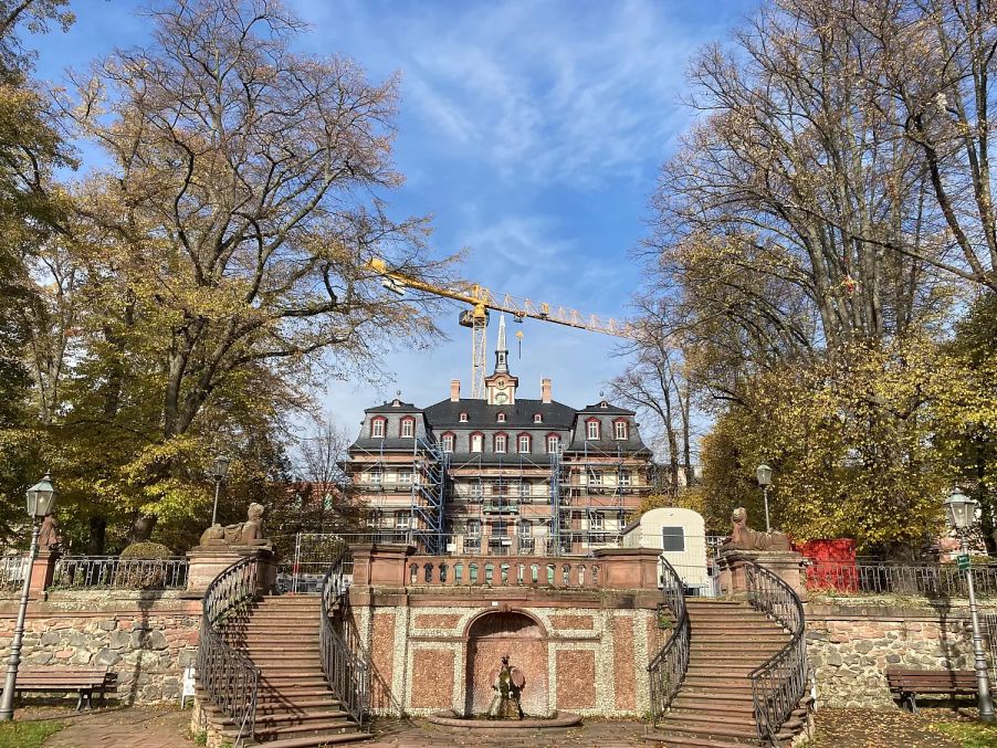 Bild vergrössern: Altes kleines Palastgeb&auml;ude mit Treppenaufg&auml;ngen zu beiden Seiten im Vordergrund und Bauger&uuml;st um das Geb&auml;ude und B&auml;umen