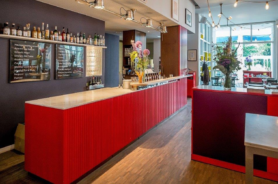 Innenansicht des Restaurants Emma Metzler im Museum Angewandte Kunst mit Blick auf die rote Bar links