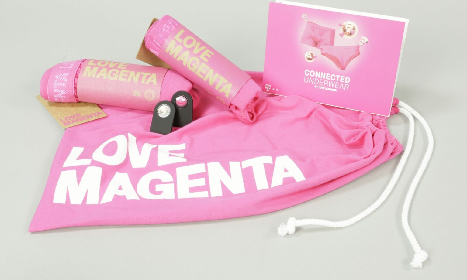 Bild vergrössern: Rosa Beutel mit der Aufschrift &quot;Love Magenta&quot; mit zwei rosa eingerollten Slips und einem rosa Flyer, auf dem die Slips zu sehen sind