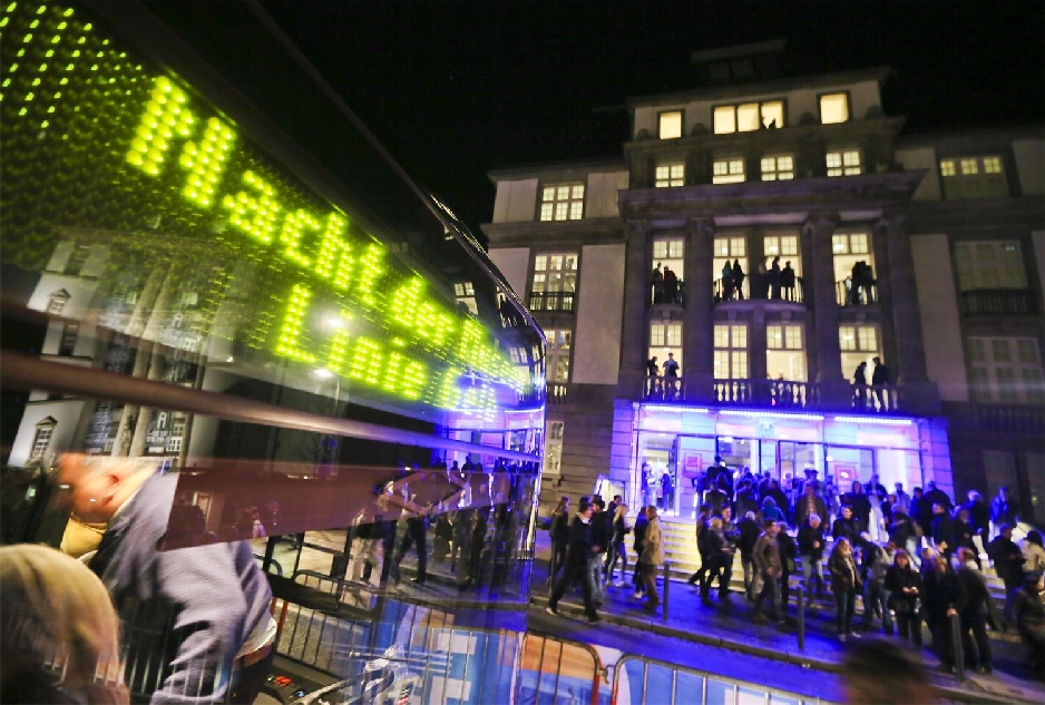 Windschutzscheibe des Nacht der Museen-Bus vor dem Eingang des Filmmuseums mit Menschen