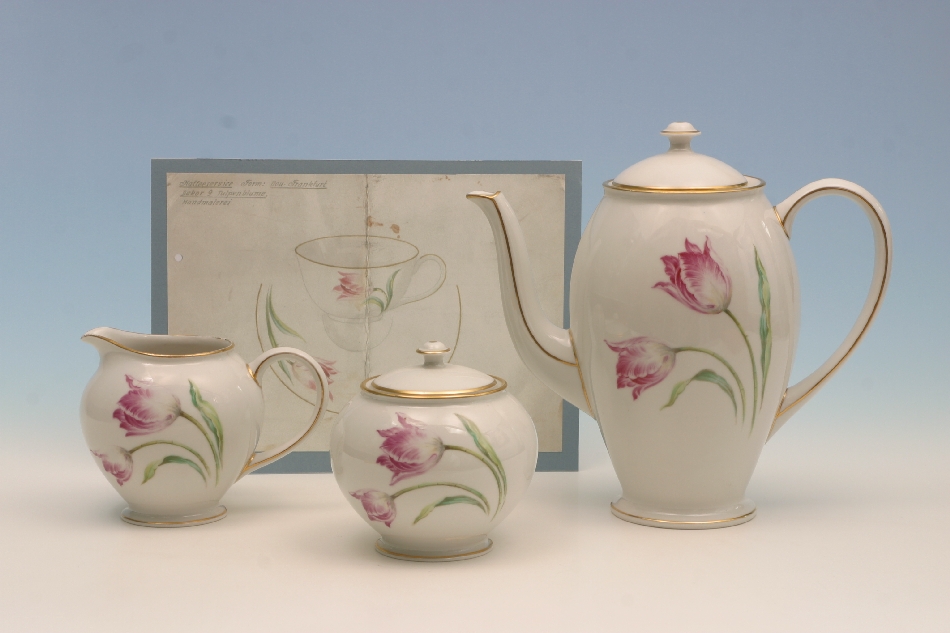 Ausstellungsstücke (v.l.n.r. Milchkännchen, Zuckerdose, Kaffeekanne mit derselben Blumenbemalung und Design) aus dem Porzellan Museum