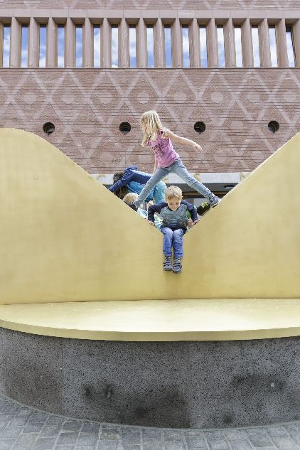 Kinder spielen auf Skulptur vor dem Eingang zum Historischen und Jungen Museums