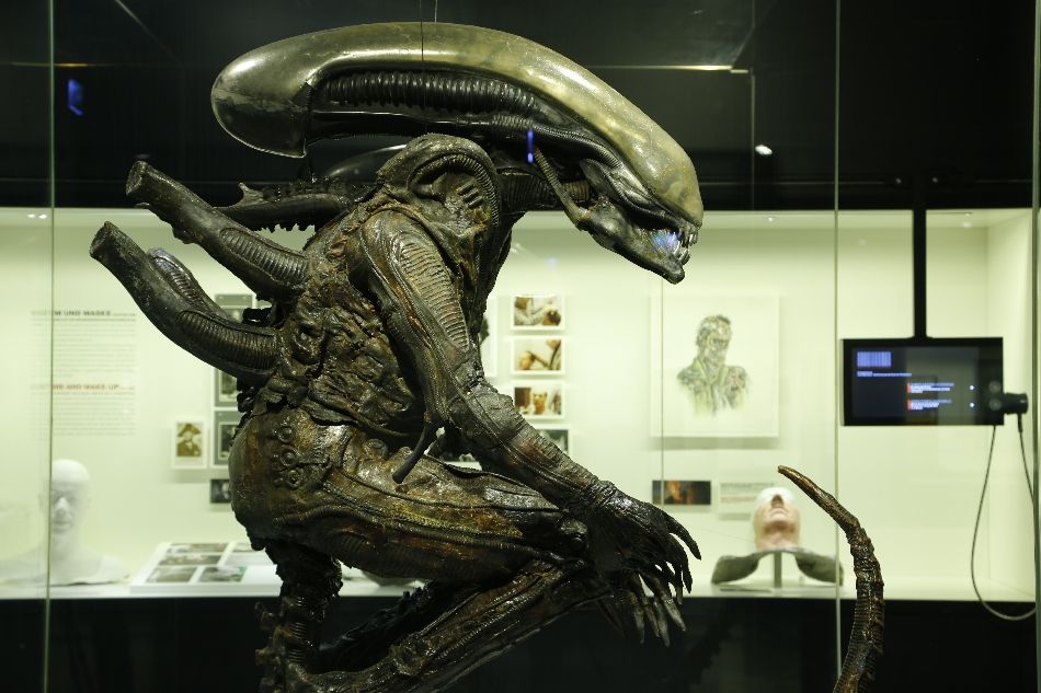 Vitrine im Filmmuseum mit Statue aus dem Horror-Sciene-Fiction Film "Alien" und weitere Vitrine im Hintergrund