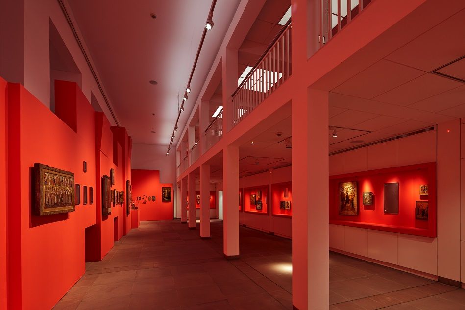 Hauptraum des Ikonenmuseums mit Ikonen an roten Wandeinbauten