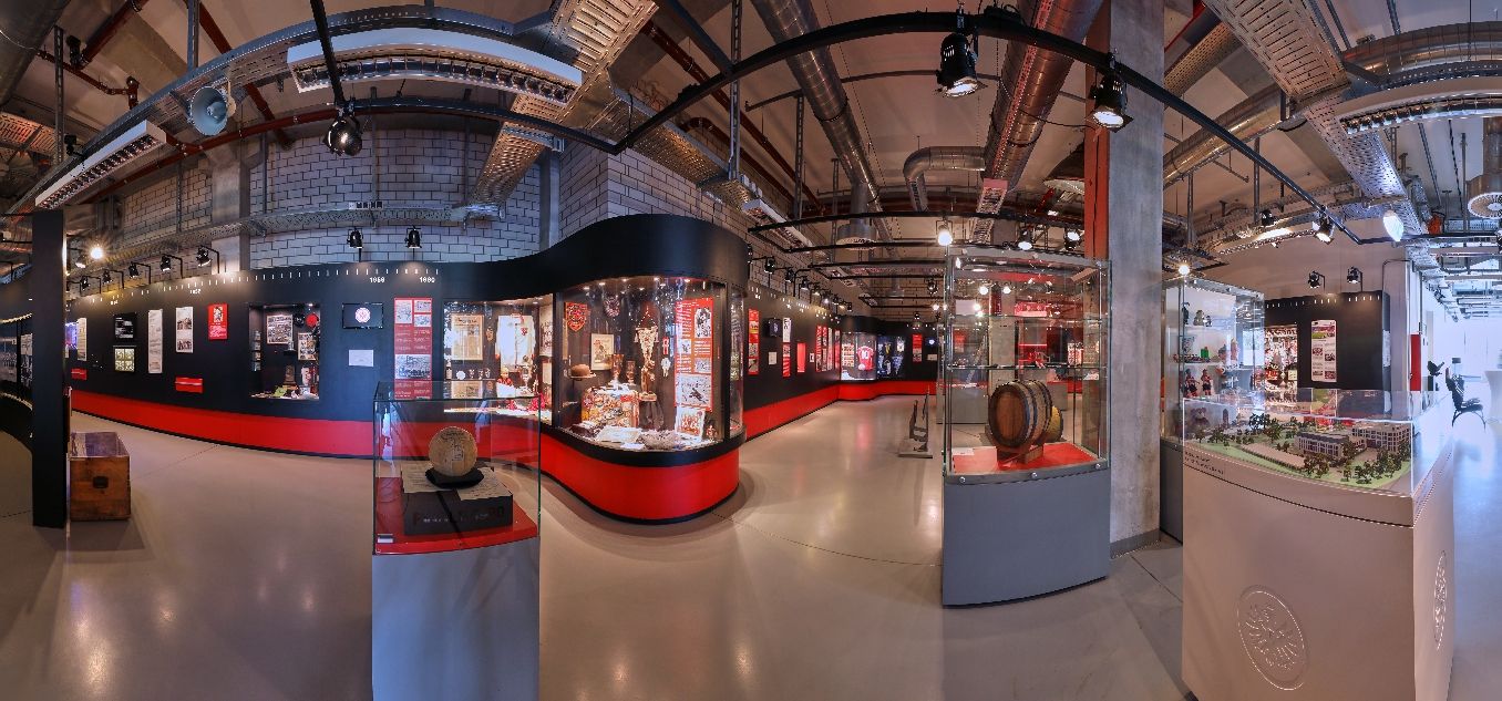 Ausstellungsansicht im Eintracht Frankfurt Museums mit Vitrinen im Vordergrund und Ausstellungswand im Hintergrund