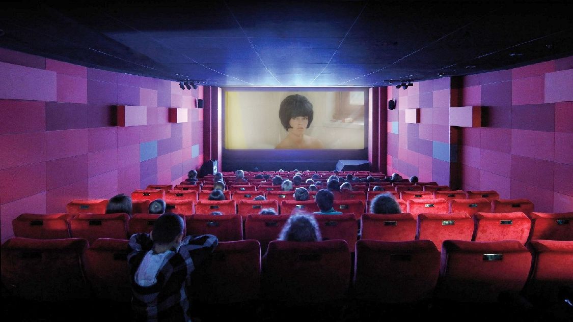 Blick von hinten über die Sitzreihen hinweg auf die Leinwand des Kinosaals im Filmmuseum