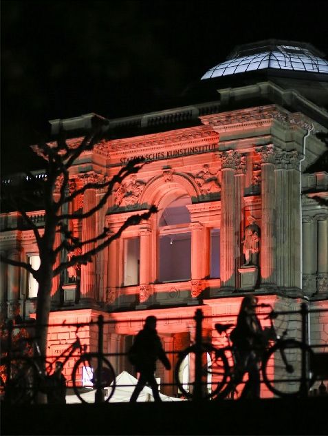 Eingang des Städel Museum in rötlichem Licht angestrahlt mit Fahrrädern im Vordergrund