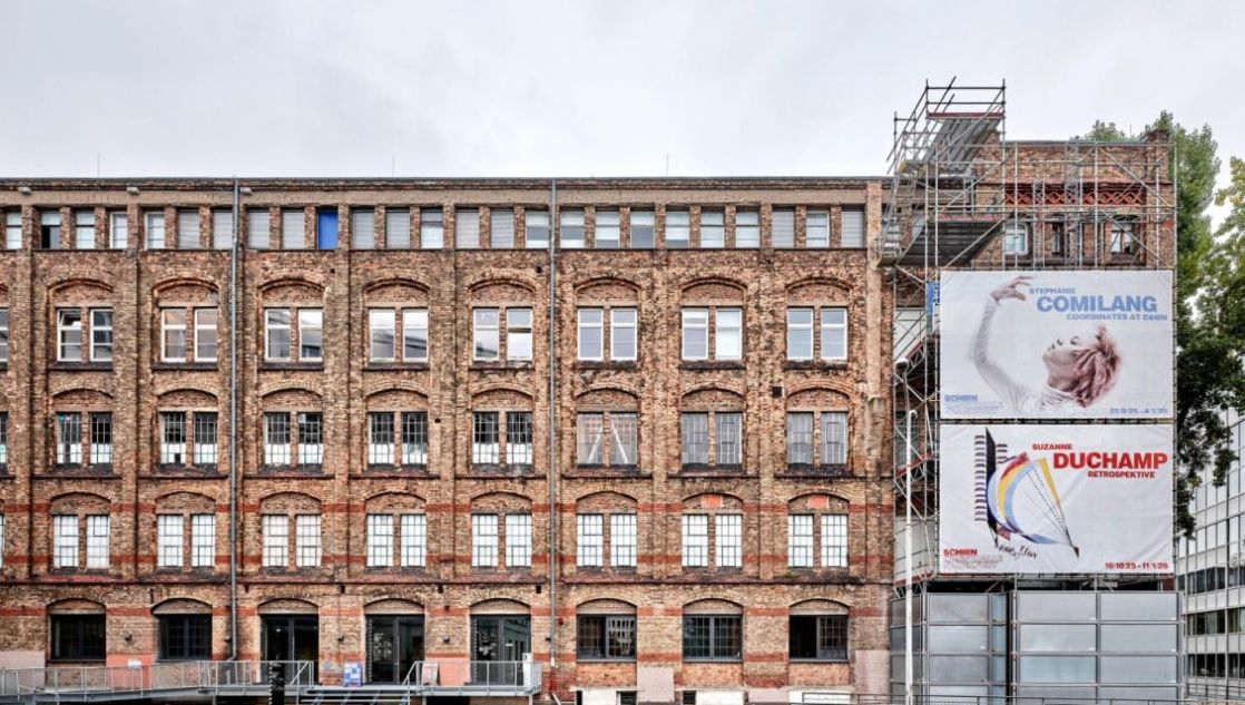 Fassade eines Backsteingebäudes mit Plakaten