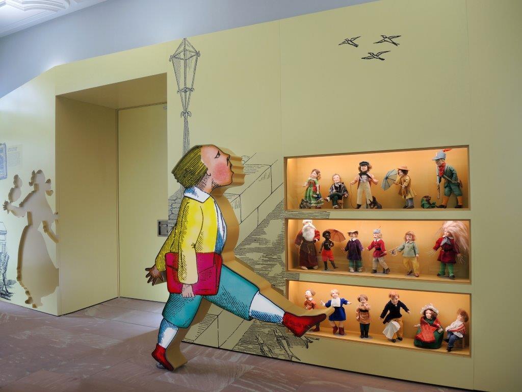 Foyer des Struwwelpeter Museums mit einem Aufsteller der Figur des Hans-Guck-in-die-Luft aus dem Struwwelpeter vor einem Regal mit mehreren Figuren aus dem Struwwelpeter-Kosmos