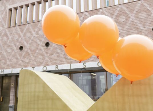 Gelborangene Luftballons vor dem Eingang zum Historischen und Jungen Museums