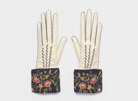 weiße Handschuhe mit Seiden-Stulpen mit Blumenmuster auf grauem Hintergrund