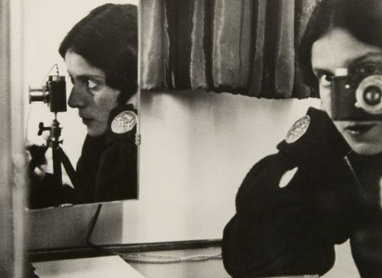 Schwarz-Weiß-Fotografie einer Frau, die sich im Spiegel selbst fotografiert