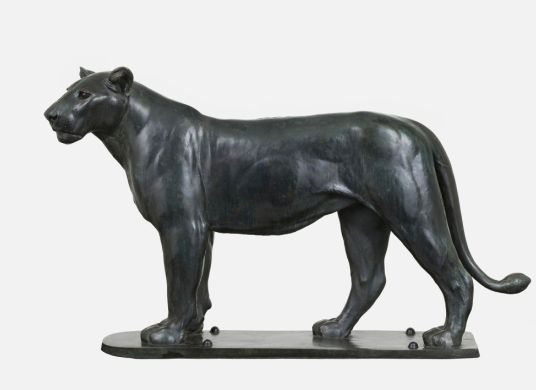 Skulptur einer schwarzen, stehenden Löwin