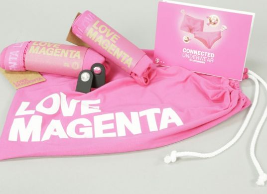 Rosa Beutel mit der Aufschrift "Love Magenta" mit zwei rosa eingerollten Slips und einem rosa Flyer, auf dem die Slips zu sehen sind