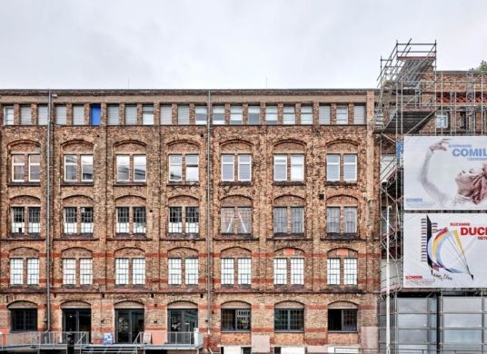 Fassade eines Backsteingebäudes mit Plakaten