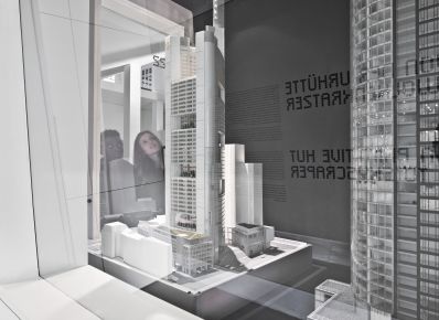 Zwei Jugendliche betrachten durch eine Glasscheibe das Modell des Commerzbank-Tower in der Dauerausstellung des Deutschen Architekturmuseums