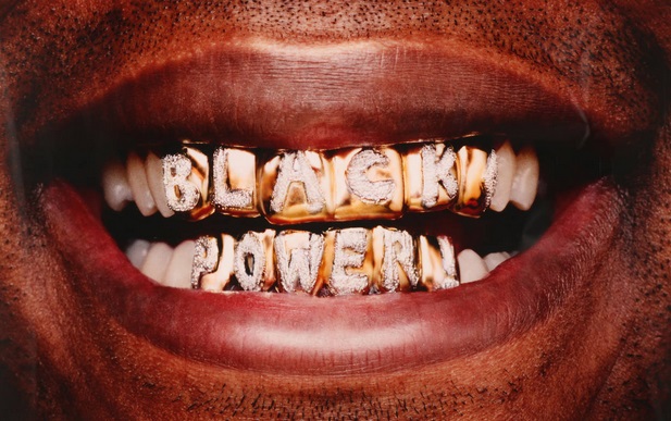 Offener Mund eines Schwarzen mit Goldzähnen, die mit "Black Power" beschriftet sind