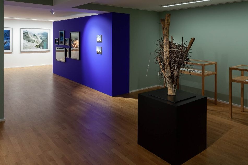 Ausstellung im Sinclair-Haus mit Skulptur im Vordergrund rechts und Fotografien im Hintergrund